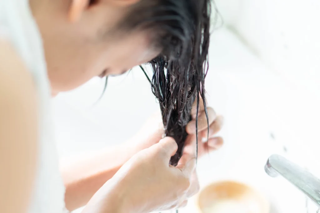 femme applique un masque pour cheveux