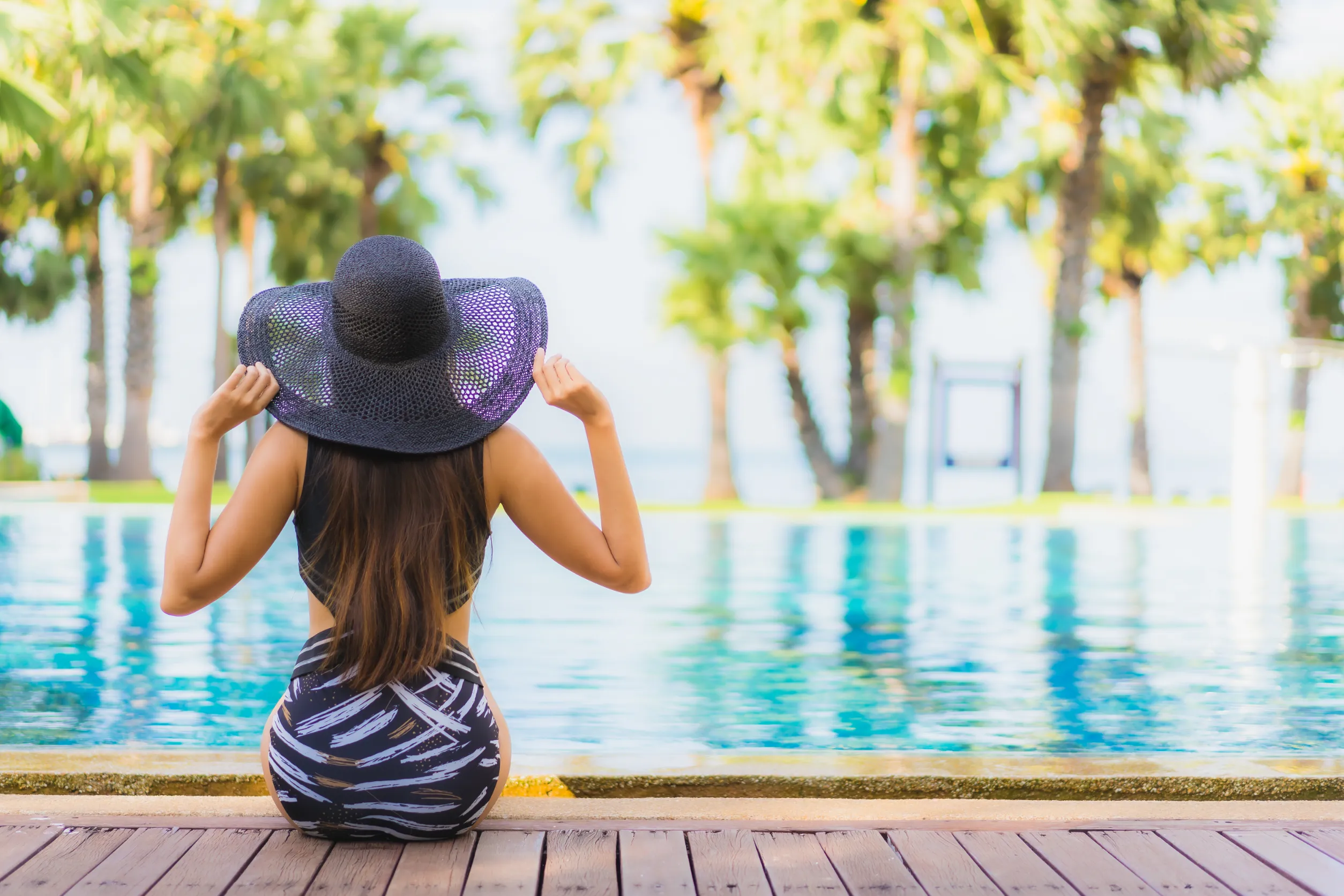 belle femme assise au bord d'une piscine